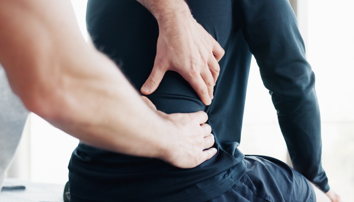 manos ejercitando zona lumbar